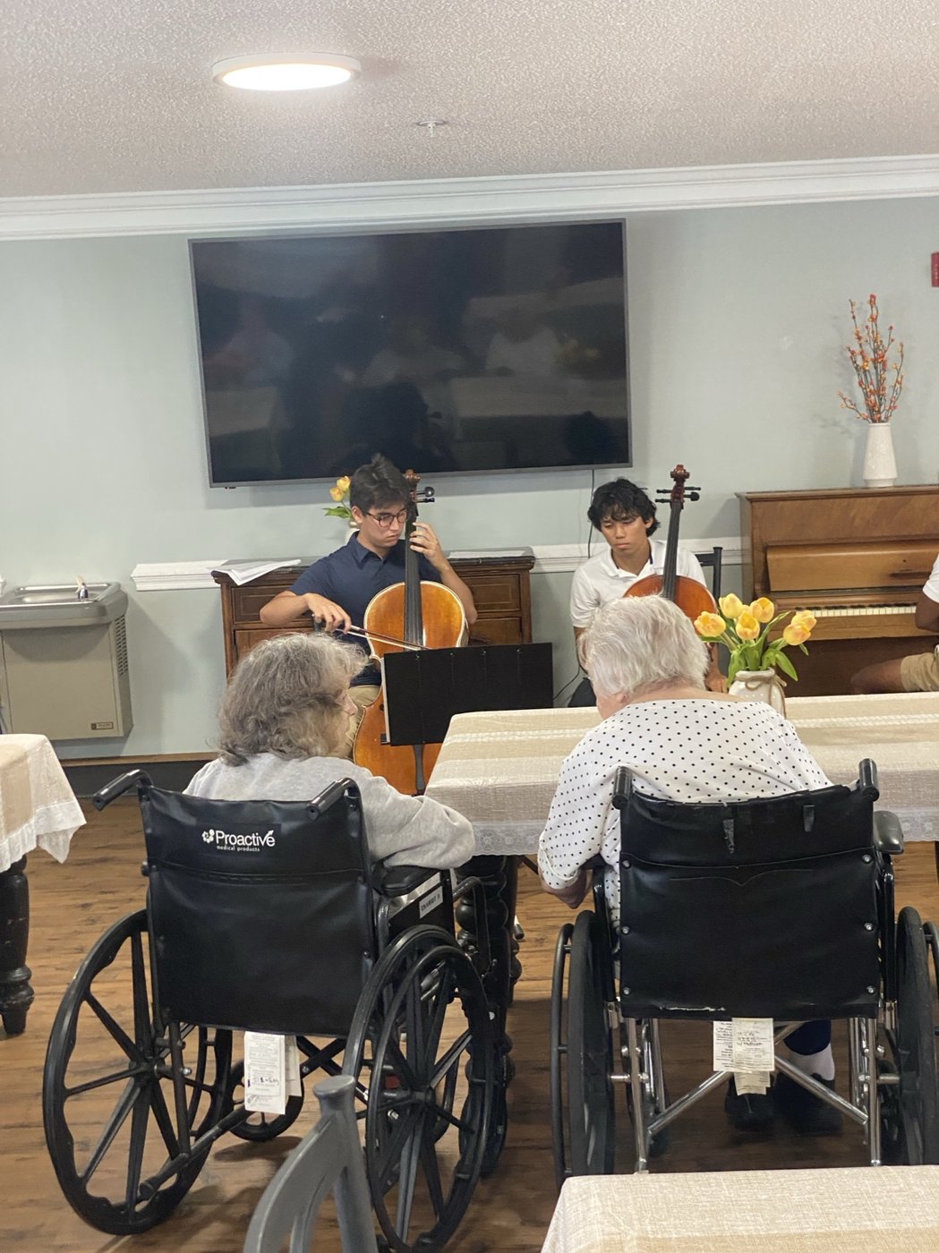 Two residents watching a cello duet during a Music & Light visit