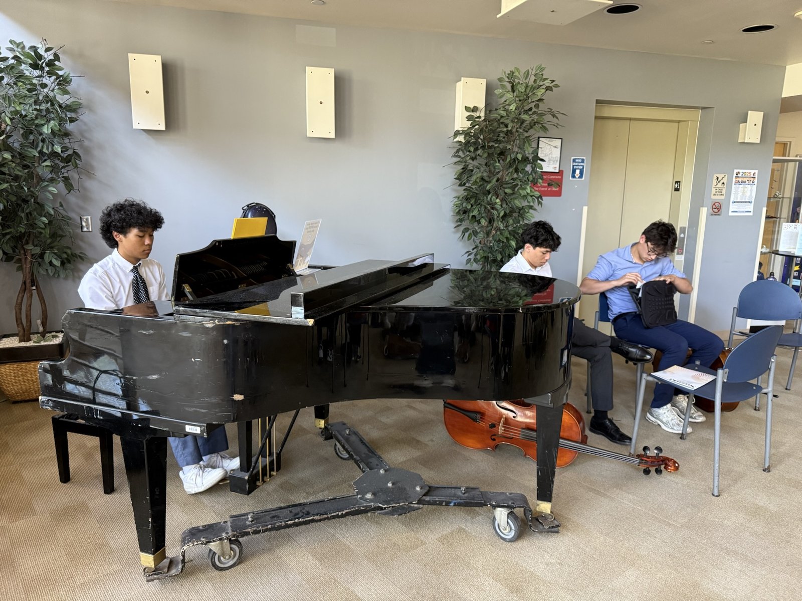 A pianist and cellists in the lobby, getting set before a Music & Light visit